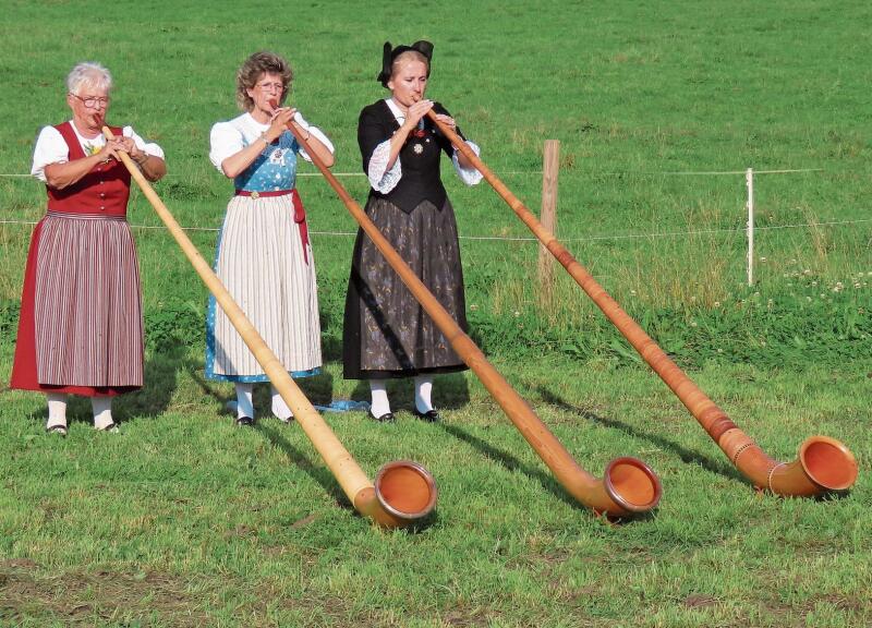 Marianne Müller-Roche, Claudine Kürsteiner und Maja Hungerbühler von der Alphornbläser-Vereinigung Zürich-Stadt bei ihrem Auftritt in Bonstetten. (Bild Marcus Weiss)