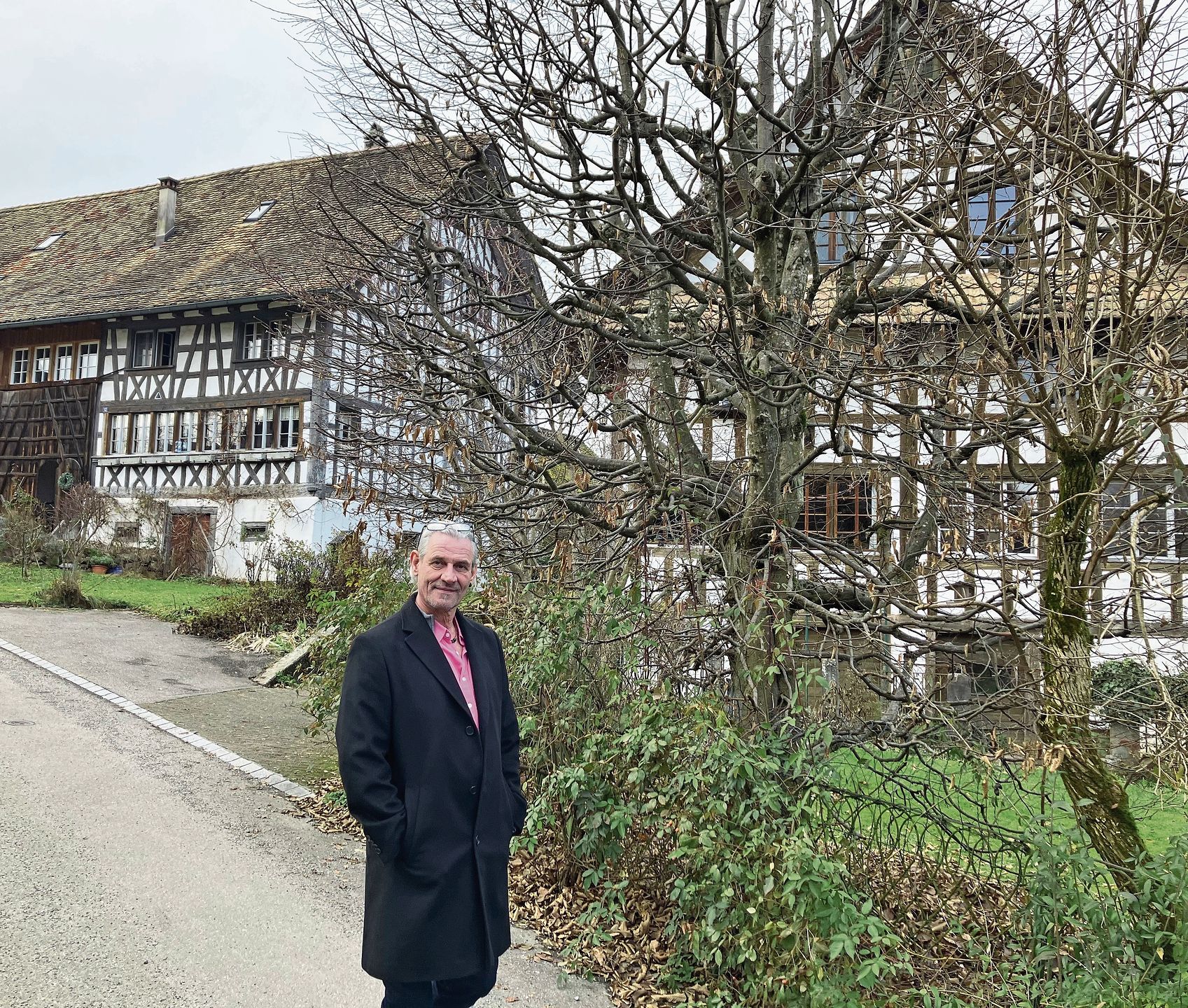 Gemeindepräsident Christoph Lüthi vor Fachwerkhäusern im Winkel.