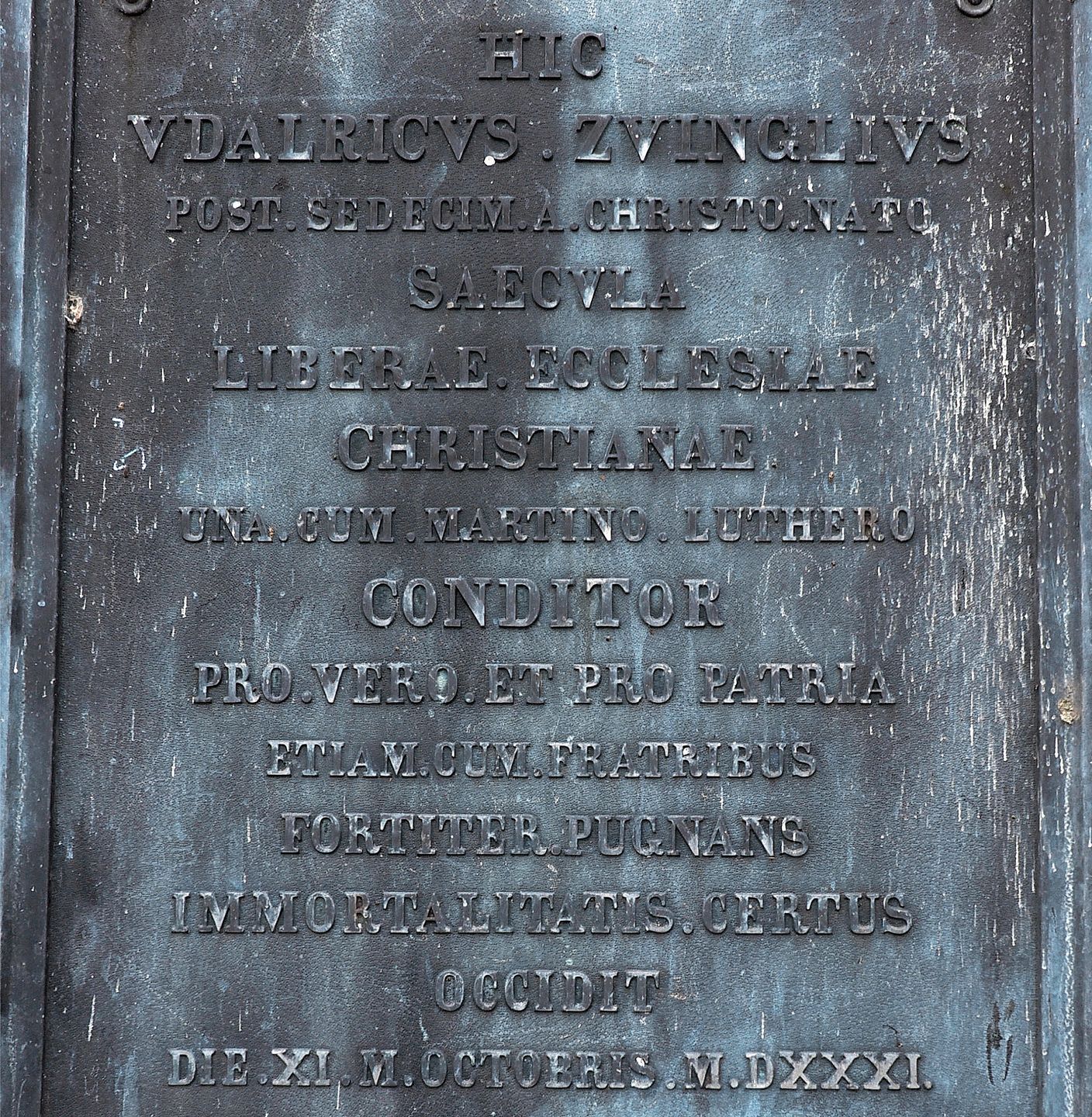 Die Zug zugewandte lateinische Inschrift des Zwingli-Steins ist bemerkenswert. In der Sprache der katholischen Kirche wurde ein aggressiverer Wortlaut gewählt: «Ulrich Zwingli, der im 16. Jahrhundert nach Christi Geburt gemeinsam mit Martin Luther Die Zug zugewandte lateinische Inschrift des Zwingli-Steins ist bemerkenswert. In der Sprache der katholischen Kirche wurde ein aggressiverer Wortlaut gewählt: «Ulrich Zwingli, der im 16. Jahrhundert nach Christi Geburt gemeinsam mit Martin Luther die freie christliche Kirche gründete, starb für die Freiheit und das Vaterland, gemeinsam mit seinen Brüdern, in tapferem Kampf, der Unsterblichkeit gewiss.»