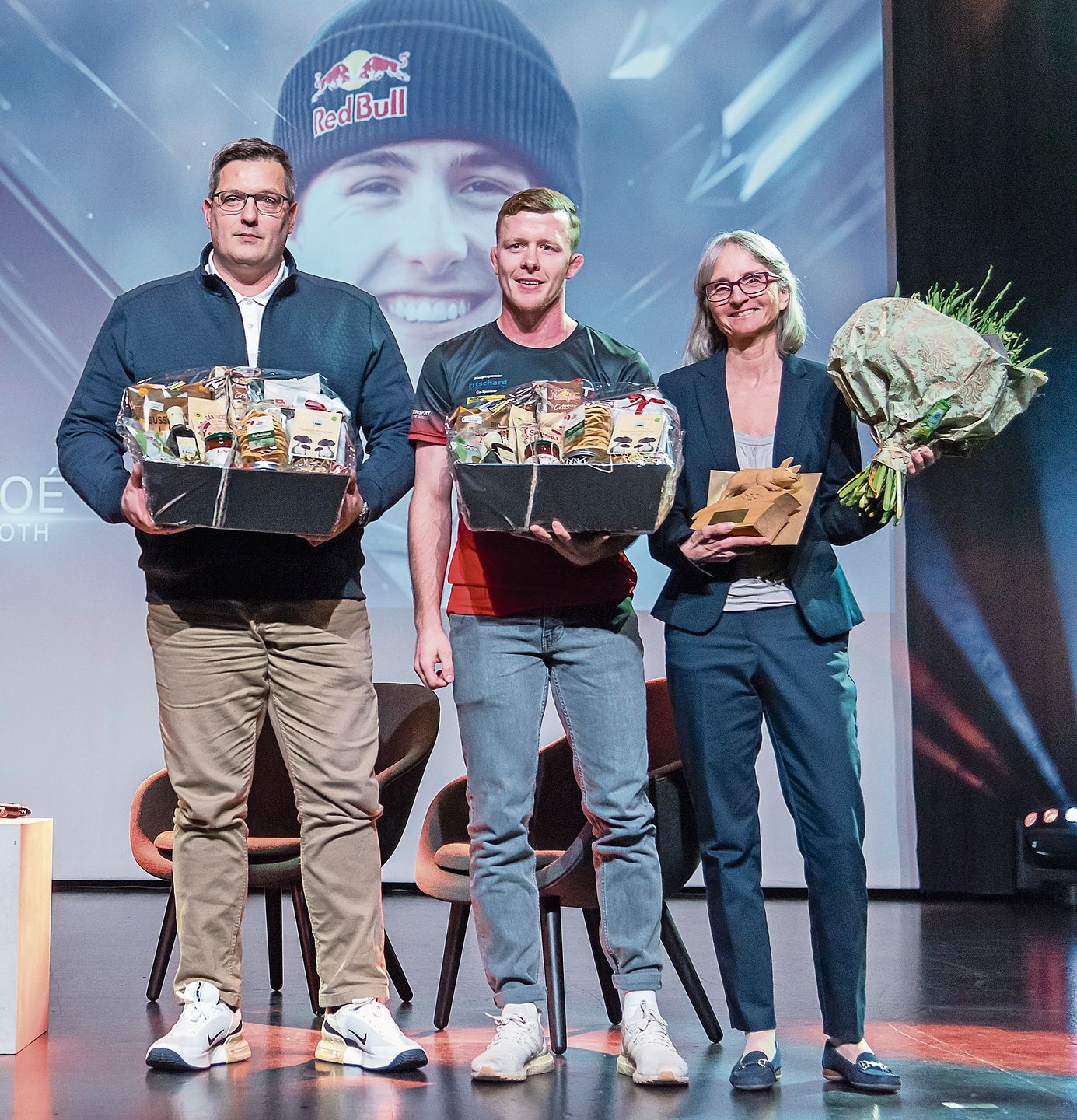 Weil in wenigen Tagen die Olympischen Winterspiele beginnen, nicht persönlich anwesend: Der Sieger in der Kategorie Männer, Noé Roth (im Bild im Hintergrund), er wurde von seiner Mutter Colette (rechts) vertreten. Daneben die mit nominierten Nino Weil in wenigen Tagen die Olympischen Winterspiele beginnen, nicht persönlich anwesend: Der Sieger in der Kategorie Männer, Noé Roth (im Bild im Hintergrund), er wurde von seiner Mutter Colette (rechts) vertreten. Daneben die mit nominierten Nino Leutert (Mitte) und René Täuscher (links).