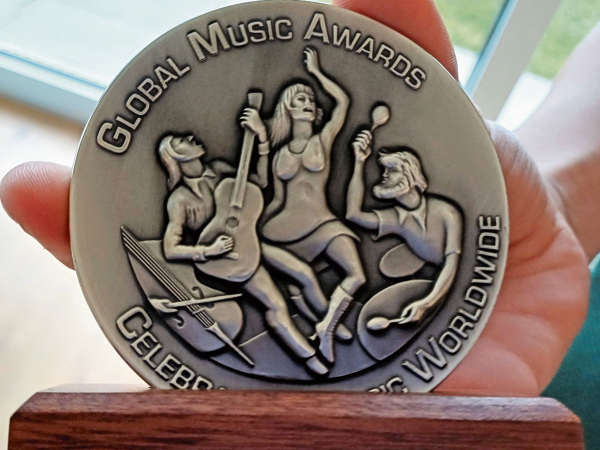 Stolz zeigt Livio Kehrli seine Medaille der Global Music Awards. Diese sind ein renommierter internationaler Musikwettbewerb, der herausragende Leistungen von Musikern, Komponisten und Produzenten in verschiedenen Genres würdigt.