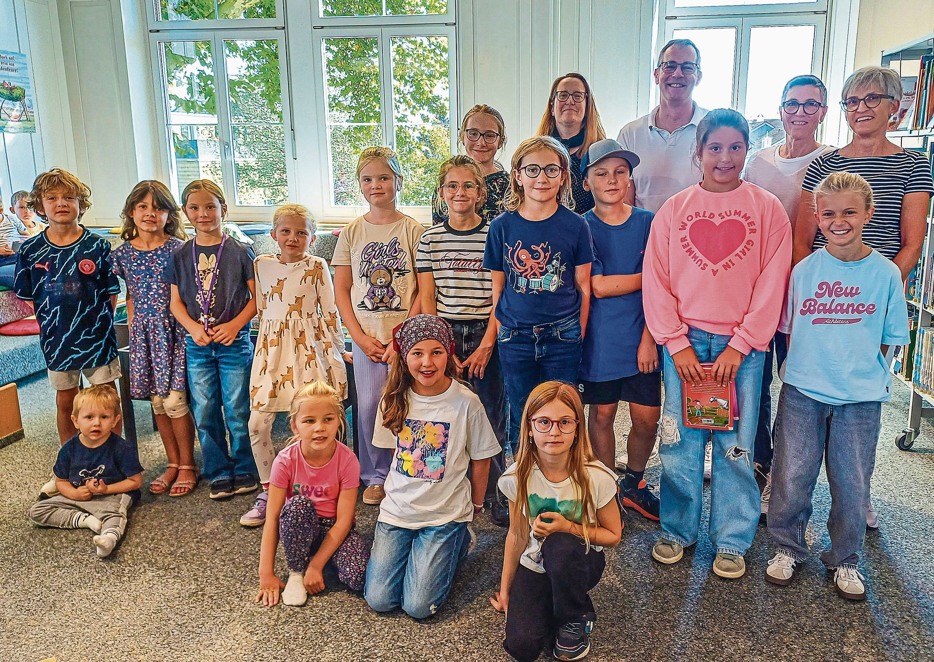 Die beteiligten Kinder und im Hintergrund das Bibliotheksteam (von links) mit Sheila Lanz, Regula Herrmann und Elisabeth Frey. Dazwischen als Vertretung der Kinder-Reha Schweiz Hubertus van Hedel.
