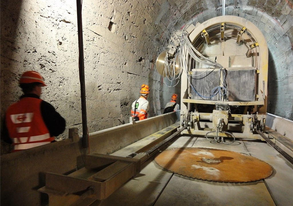 Die Gewölbefräse schafft Platz für massive Betonrippen mit Stahlträgern.Überall Risse und Wasser: das Gewölbe vor der Sanierung.Überraschend dick: die Betonschicht vor dem Portal auf Wettswiler Seite.Solider als es den Anschein macht: Das Tuffsteingewölbe in der Mitte des Tunnels.Abtransport: Der Schutt muss quer durch den Tunnel.Schalung für den neuen Portalvorbau auf Birmensdorfer Seite.Die Betonsohle wird eingebaut. (Bilder SBB / Amberg / tst.)Graben für neue Entwässerungsleitungen.