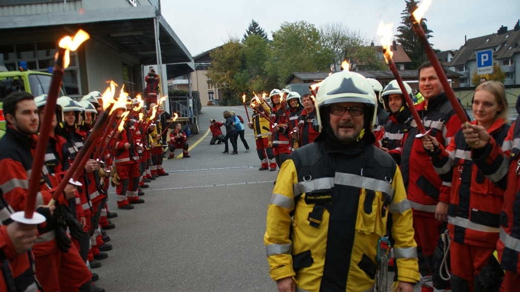 Sichtlich gerührt schreitet Roger Lochmatter durchs Fackel-Spalier der Feuerwehrleute. (Bilder tst./zvg.)