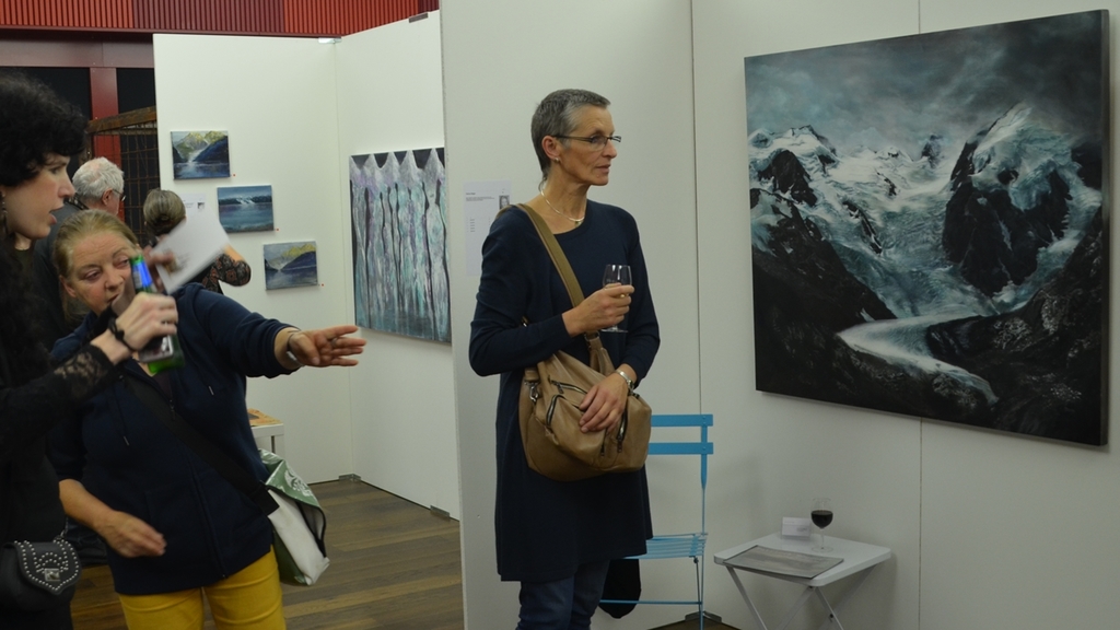 Staunen und diskutieren vor einer Alpen-Landschaft in Öl von Patricia Högger.
