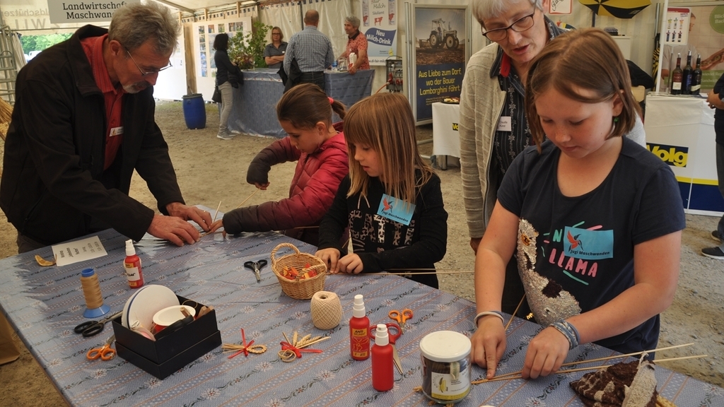 Im Bauernzelt bei Claudia und Ruedi Künzi das Handwerk des Strohflechtens lernen: Kinder stellen «Liebesknoten» her. <em>(Bilder Werner Schneiter)</em> Im Bauernzelt bei Claudia und Ruedi Künzi das Handwerk des Strohflechtens lernen: Kinder stellen «Liebesknoten» her. <em>(Bilder Werner Schneiter)</em>